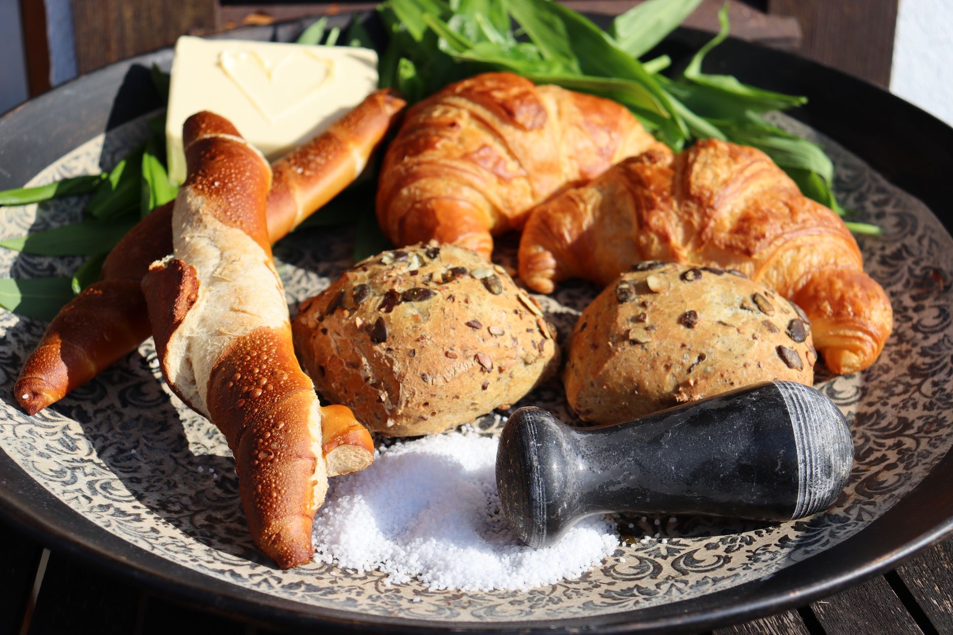 Frische Croissants und Brezeln mit Butter und Salz